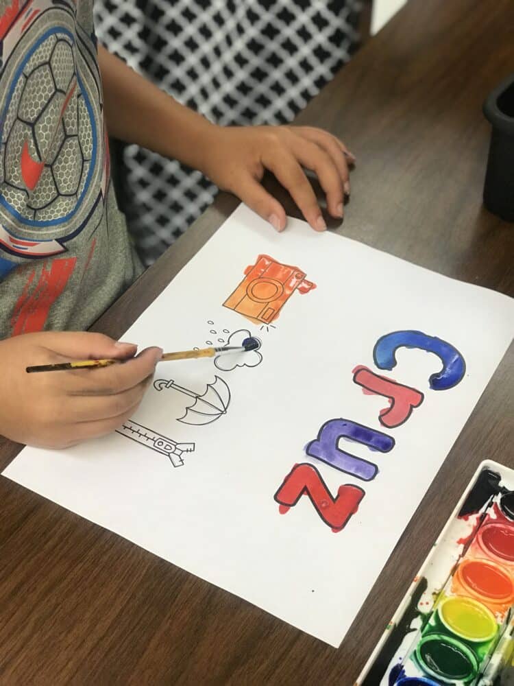 Painting names in letters and pictures with watercolor paints.